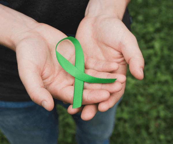 Two palms holding out a green ribbon.